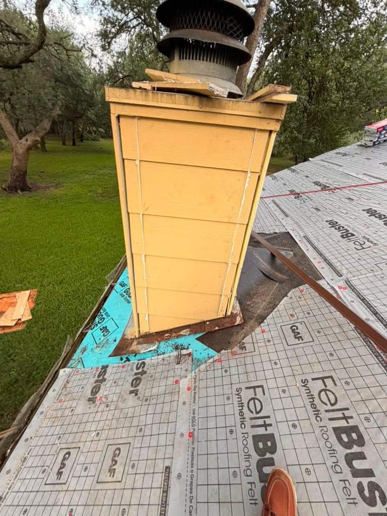 Chimney with old flashing stripped out, surrounded by StormGuard leak barrier and GAF FeltBuster