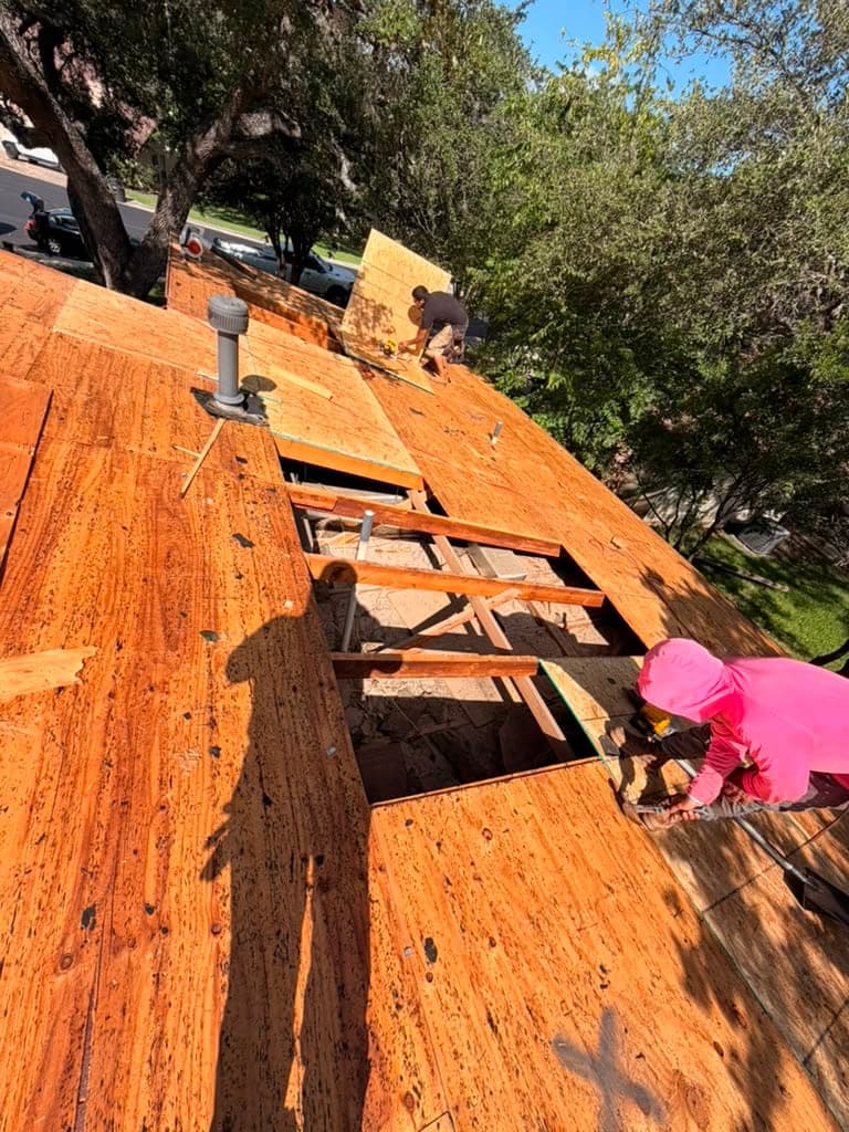Rotten roof decking removed down to open rafters with new plywood going back in