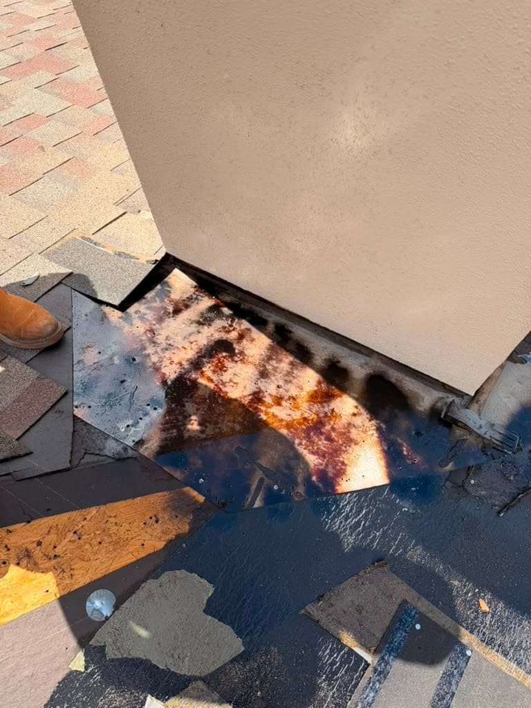 Old sidewall flashing exposed after shingle removal, rusted and corroded through